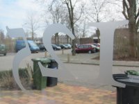 Huisnummer aan de binnen kant van een raam geplakt Een huisnummer in gezandstraald gels effect vinyl